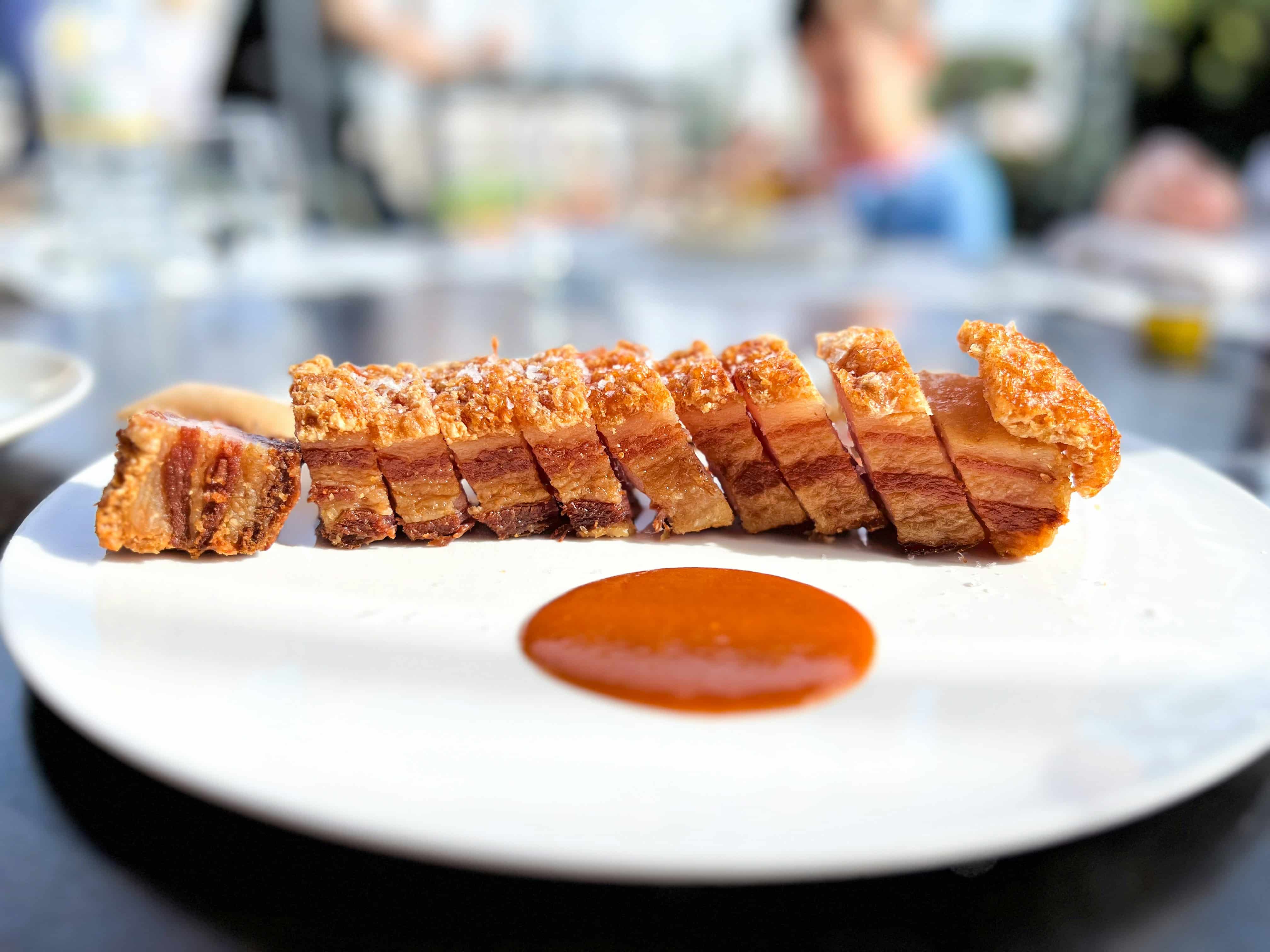 Primer plano de tapas típicas sobre una barra en El Tubo, Zaragoza, con clientes probando diferentes platos tradicionales